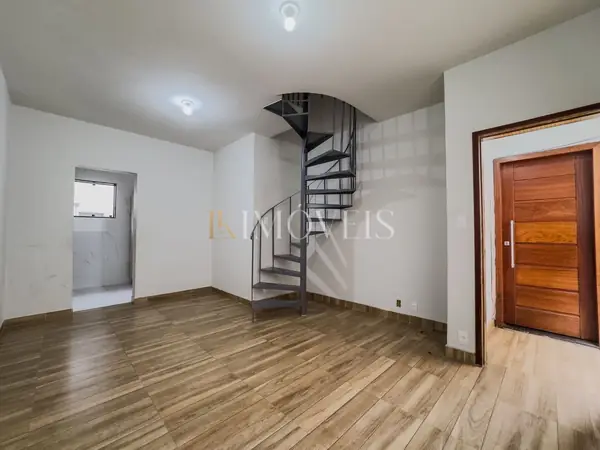 Sala do apartamento com piso de madeira e escada em caracol, no bairro Lourdes